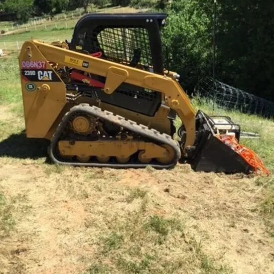 Skid steer digging fence line