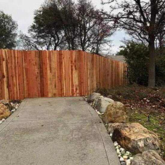 Wood privacy fence installation driveway